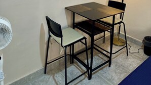 A small room with a framed map of the Grand Canyon, a table with two chairs, a standing lamp, and a white fan. - Apt. with double bed and patio 20 min. from the historical center (Heroica Puebla de Zaragoza)