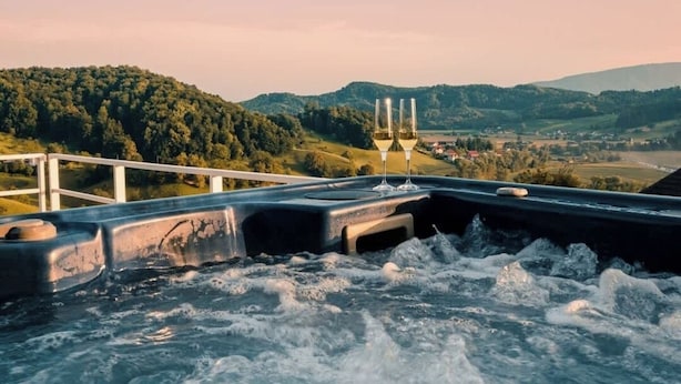 A hot tub with a view of a hilly landscape.