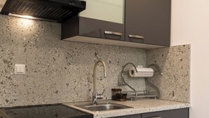 A kitchen with a granite countertop, stainless steel sink, and a built-in stove.