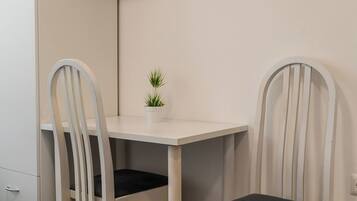A small, white, rectangular table with a single potted plant in the center.