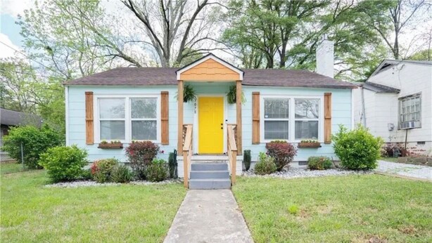 A single-story house with a front porch, a yellow door, and a small front yard. - 12 Min to Mercedes-Benz Stadium  2BR Sleeps 5  4 Min to MARTA (East Point)