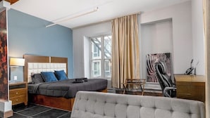 Een slaapkamer met een bed, een bureau, een stoel en een bank.