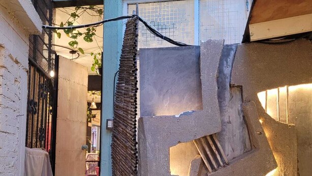 A narrow staircase with a textured wall, a small potted plant, and a view into a room with a table and chairs. - Our guests appreciate the excellent location, comfort, service, and Wi-Fi (Oaxaca de Juárez)