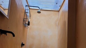 A small bathroom with a skylight, a shower, a sink, and a wooden bench. - Our guests appreciate the excellent location, comfort, service, and Wi-Fi (Oaxaca de Juárez)
