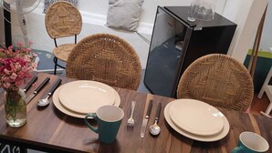 A dining table set with plates, a mug, cutlery, and a fan in the background. - Our guests appreciate the excellent location, comfort, service, and Wi-Fi (Oaxaca de Juárez)