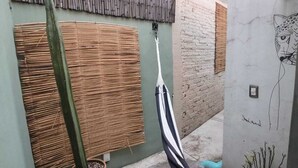 A small outdoor area with a bamboo fence, a cactus, a hammock, and a wall with a drawing. - Our guests appreciate the excellent location, comfort, service, and Wi-Fi (Oaxaca de Juárez)