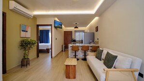A modern living room with a sofa, a small table, and a bar area. - Arenal Volcanic Villas (La Fortuna)