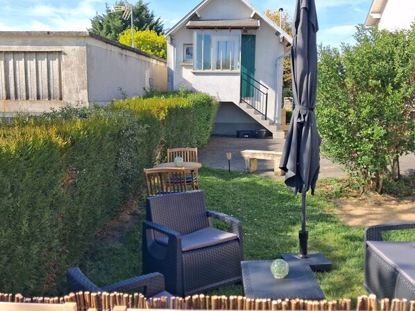 A patio area with outdoor furniture, a small table, and a bench.