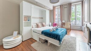 Una camera da letto moderna con un letto, armadio a muro, comodino e vista sull'esterno.
