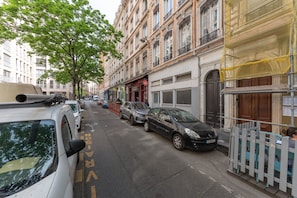 A street with parked cars, buildings with balconies, and a tree. - Le Mercière - Charmant Cocoon au cœur de Lyon (Lyon)