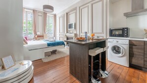 Una cucina moderna con isola centrale, lavatrice e zona pranzo con vista.