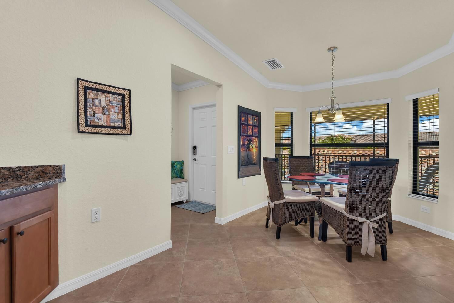 A dining area with a table and chairs, a kitchen counter, and a door leading to another room.