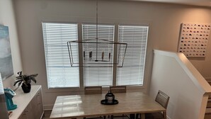 A dining area with a wooden table, benches, and a hanging light fixture. - FIFA 2026 RETREAT - 2BR Sleeps 6 - Bikes - BeltLine to Stadium - Walkable (Atlanta)