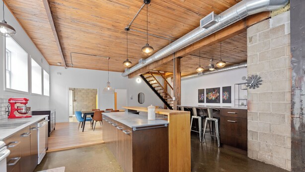 A modern kitchen with a central island, wooden ceiling, and exposed ductwork. - Rêve St-Viateur (Joliette)