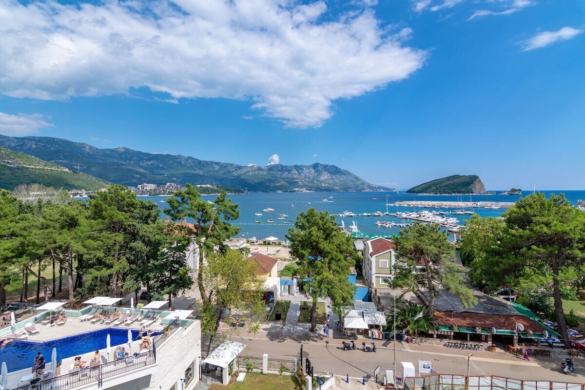 A coastal town with a swimming pool, buildings, and a marina.