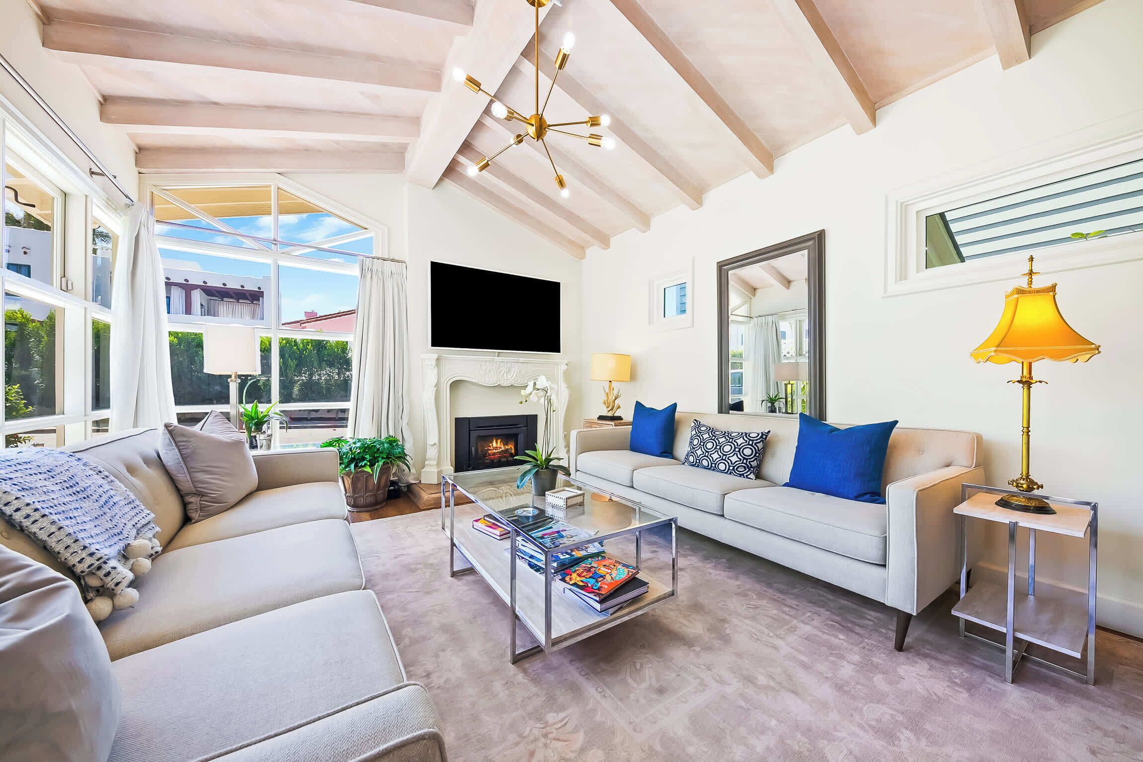 Una sala de estar con sofá, mesa de centro, chimenea y televisor.