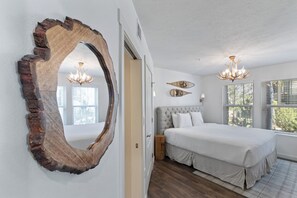 Ein Schlafzimmer mit einem großen Bett, einem hölzernen Wandbogen und zwei Kronleuchtern.