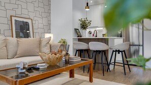 Ein modernes Wohnzimmer mit einer Couch, einem Couchtisch und Barhocker.