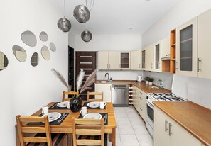 Een moderne keuken met houten kastjes, een RVS vaatwasser en een gasfornuis.
