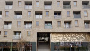 A multi-story building with balconies, a staircase entrance, and a glass facade. - Street Art Loft Apartment (Wrocław)