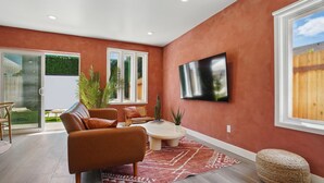 Un salon moderne avec un canapé, une table basse et un téléviseur fixé au mur.