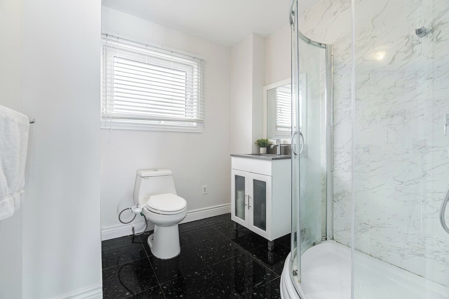 A bathroom with a toilet, sink, and shower.