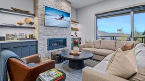 A modern living room with a fireplace, a large TV, and a cozy seating area. - Abode at Canyons Retreat, hot tub, 4 king suites (Park City)