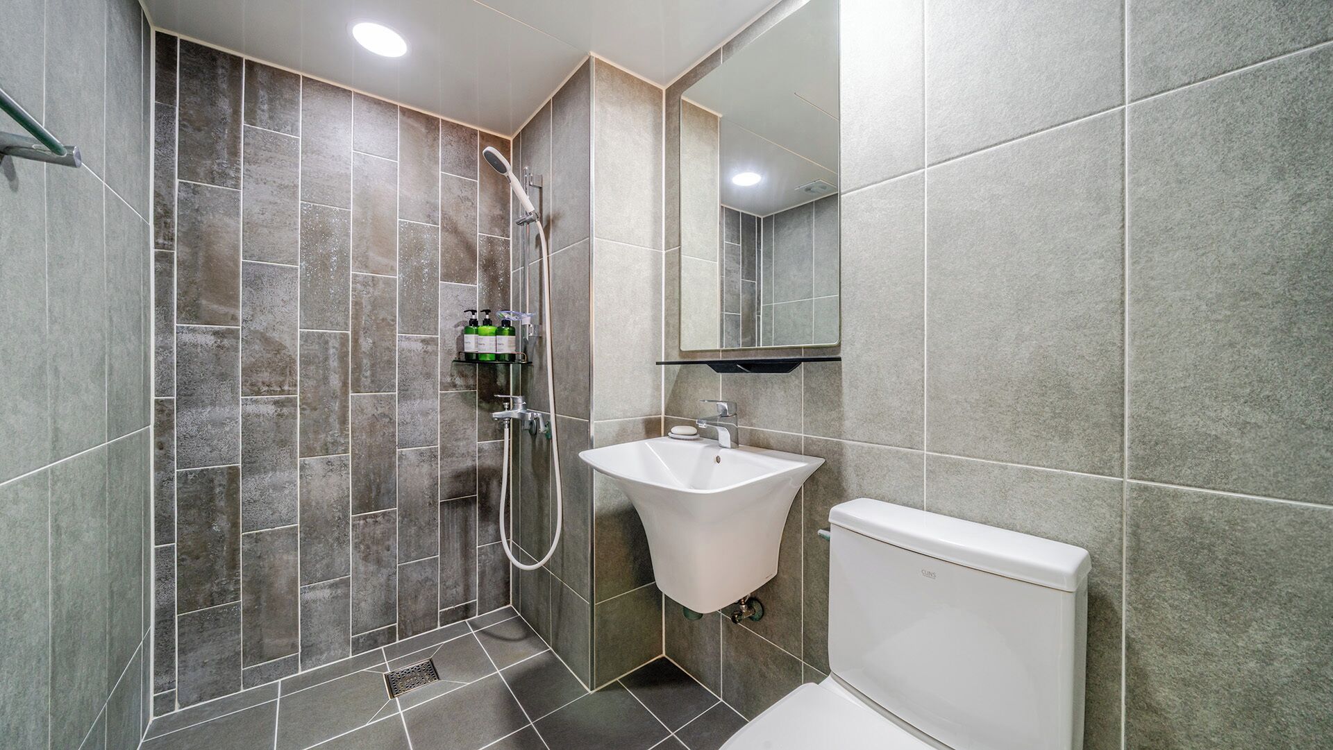 Une salle de bain moderne équipée d’une douche, d’un lavabo et de toilettes.