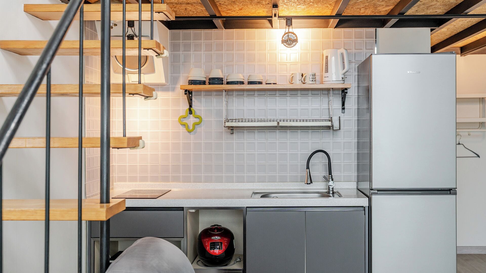 A kitchen with a built-in dishwasher, a sink, and a refrigerator.