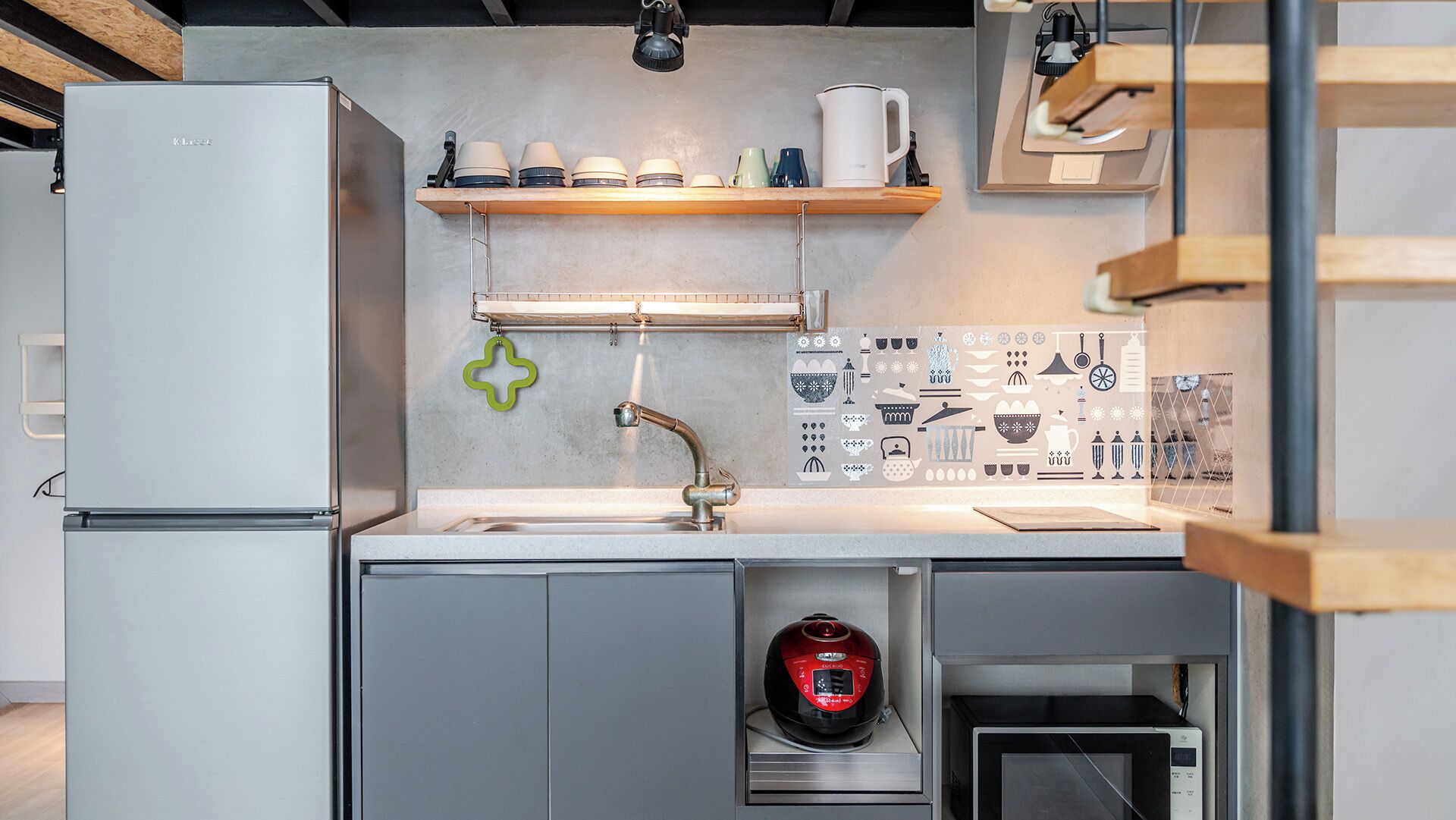 A modern kitchen with a built-in refrigerator, a coffee machine, and a kettle.