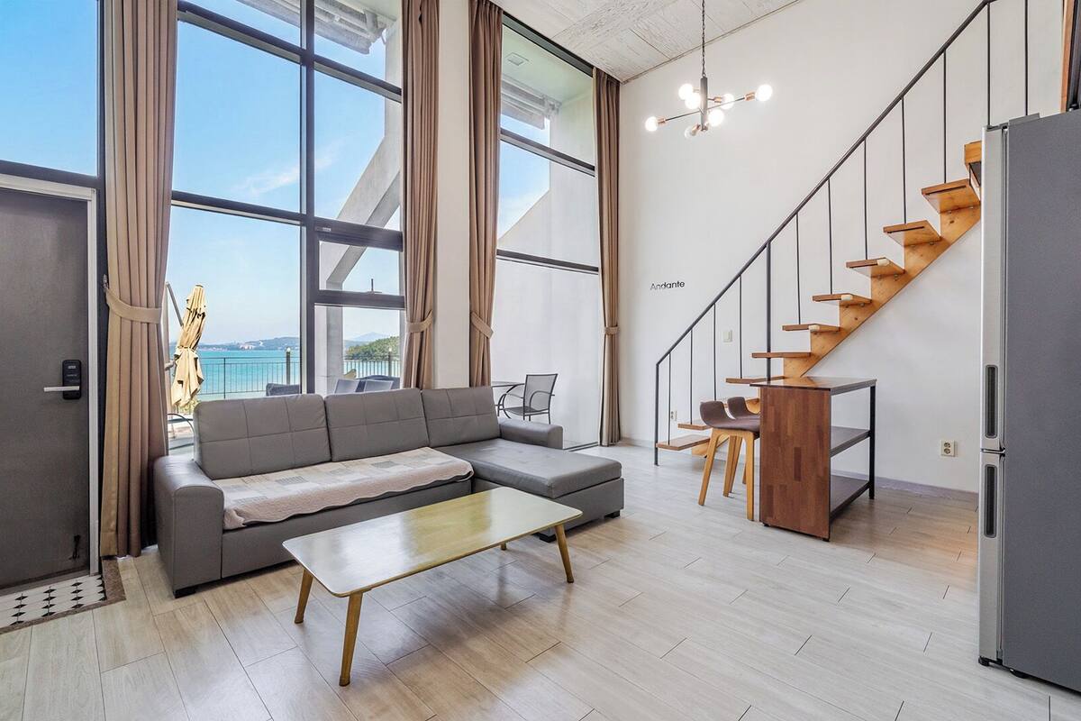 A modern living space with a sofa, coffee table, and a staircase.