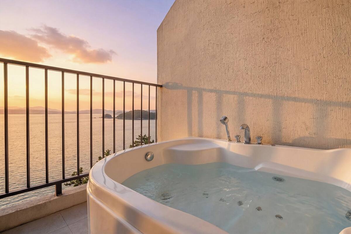 A hot tub on a balcony with a view of the sea.