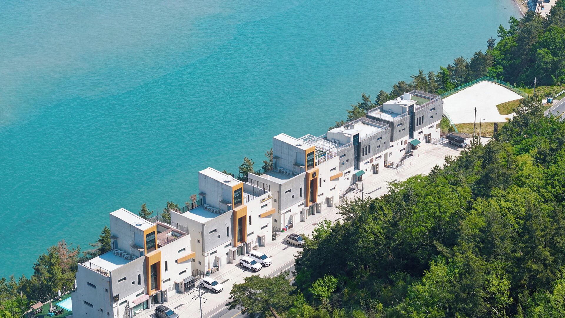 Un hotel costero con arquitectura moderna, piscina y vistas al mar.