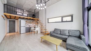 A modern apartment with a loft bedroom, a kitchen, a dining area, and a living room. - Yeosu Andante Spa Pension (Yeosu)