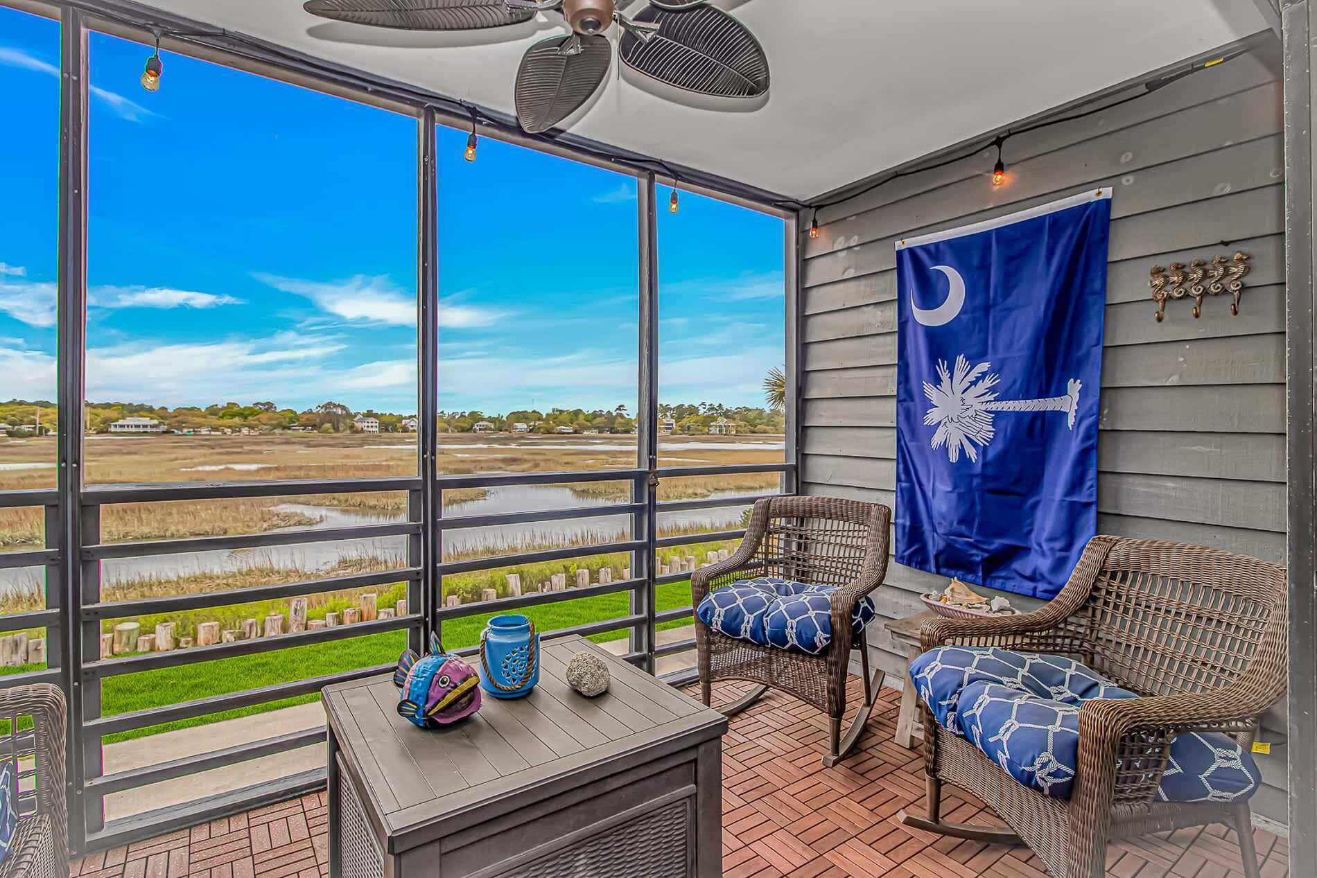 A balcony with wicker chairs, a table, and a flag.