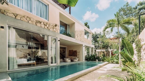 A modern two-story house with a swimming pool, large windows, and a stone facade. - Villa Selva | 4BR Villa w/ Private Pool & Rooftop (Tulum)