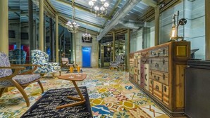 A spacious room with a patterned floor, a wooden cabinet, and a chandelier. - Mosaic Mussoorie (Dehradun)