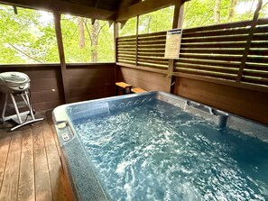 A hot tub with wooden flooring, a grill, and a wooden bench. - Silver Maple Summit | Hot Tub, Game Loft, Prime Gatlinburg Location-Pet firendly-Free Tickets (Gatlinburg)