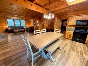 A wooden cabin interior with a dining area, kitchen, and living space. - Silver Maple Summit | Hot Tub, Game Loft, Prime Gatlinburg Location-Pet firendly-Free Tickets (Gatlinburg)