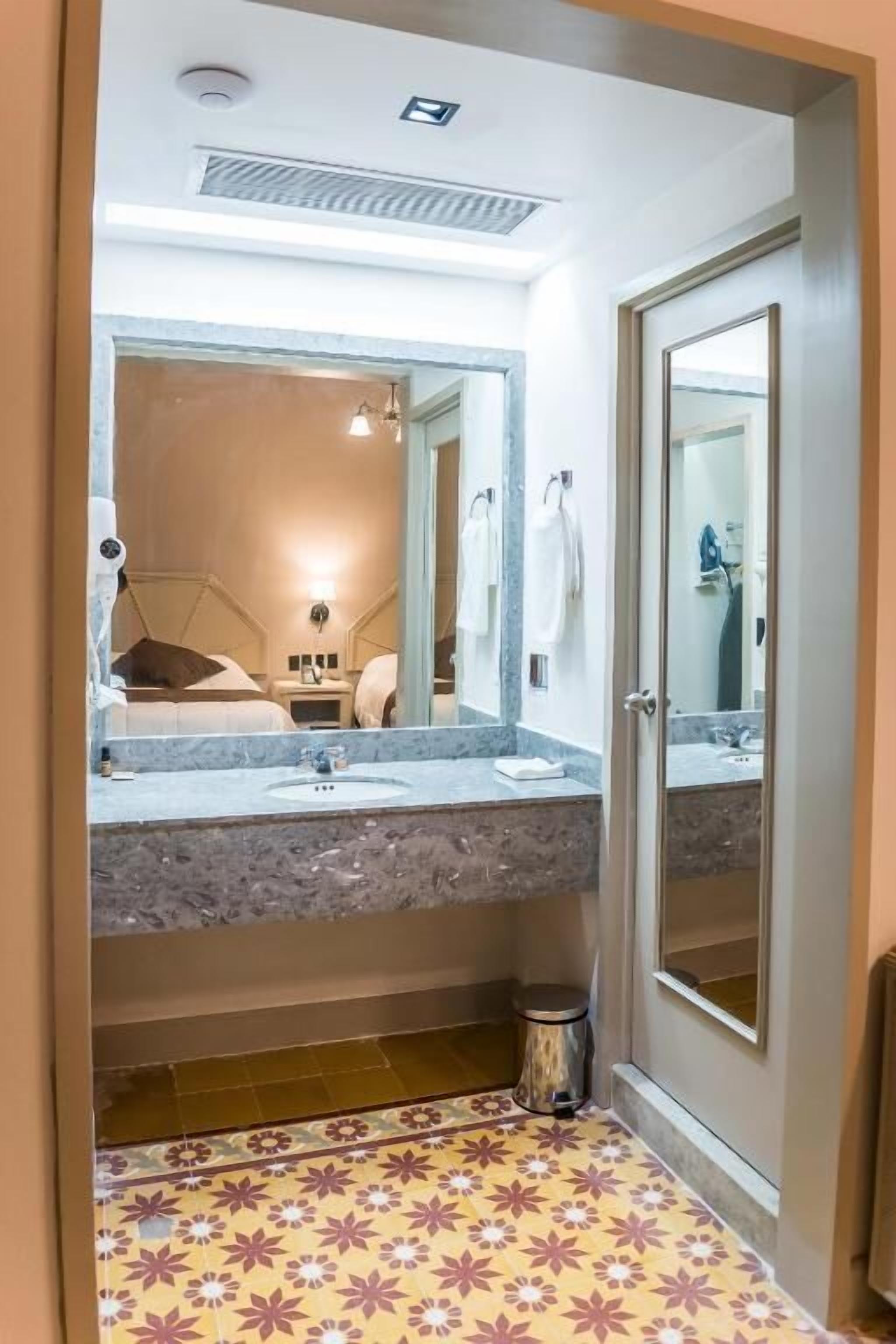 Un baño con un espejo grande, lavabo, inodoro y cabina de ducha.