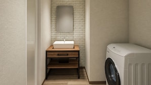 Una lavandería con lavadora, un lavabo y un espejo sobre un mueble de madera.