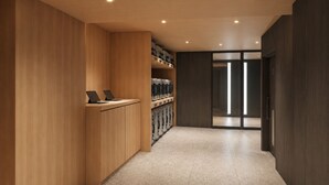 Un pasillo con paneles de madera, un mostrador con una computadora portátil y una puerta de cristal que da a otra habitación.