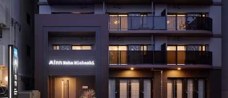 Een modern hotel met een opvallend bord waarop 'Minnanaha Miebashi' staat. Het heeft een gebouw van twee verdiepingen met balkons en grote ramen.