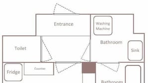 Plano de planta que muestra entrada, zona de cocina, dos baños, cama doble, cama individual, sofá, televisor y mesa de televisión.