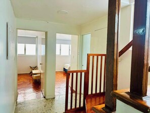 A spacious interior with a wooden staircase, a dining area, and a view of a bedroom through an open door. - Two-Level PH | Polanco · Near Masaryk · 4BR (Mexico City)