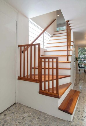 A staircase with wooden handrails and steps, leading to an upper floor. - Two-Level PH | Polanco · Near Masaryk · 4BR (Mexico City)