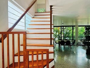 A wooden staircase leading to a dining area with a view of greenery outside. - Two-Level PH | Polanco · Near Masaryk · 4BR (Mexico City)