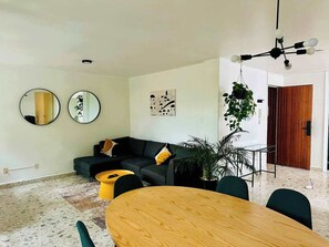 A modern living room with a sofa, a round wooden table, and a hanging light fixture. - Two-Level PH | Polanco · Near Masaryk · 4BR (Mexico City)