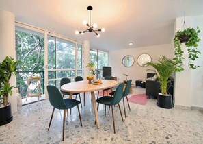 A modern dining area with a round table, chairs, and potted plants. - Two-Level PH | Polanco · Near Masaryk · 4BR (Mexico City)