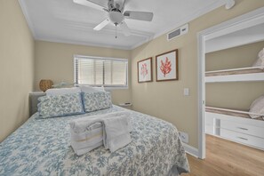 A bedroom with a bed, a ceiling fan, a window with blinds, and a bunk bed. - Beachside Bliss - Beachfront Condo! (Hilton Head Island)